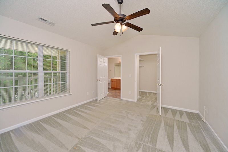 Beacon master bedroom with window view of patio, bathroom, and walk-in closet