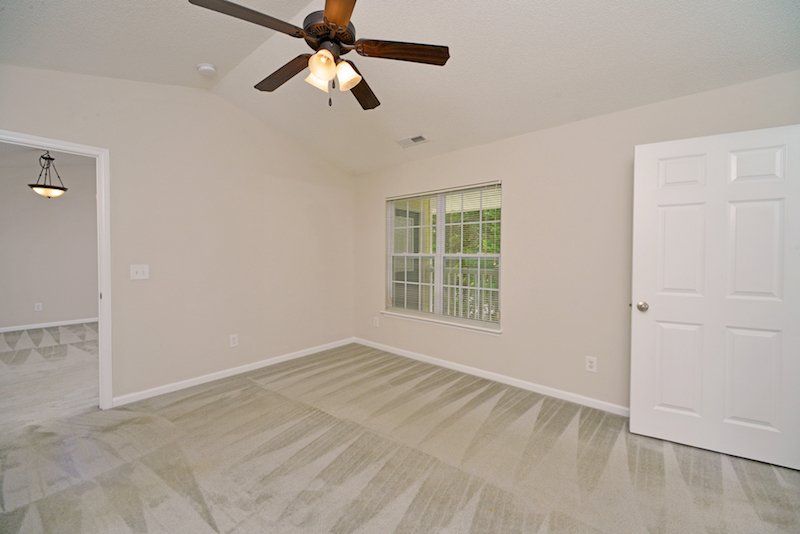 Beacon master bedroom with view of patio from window and walk-in closet