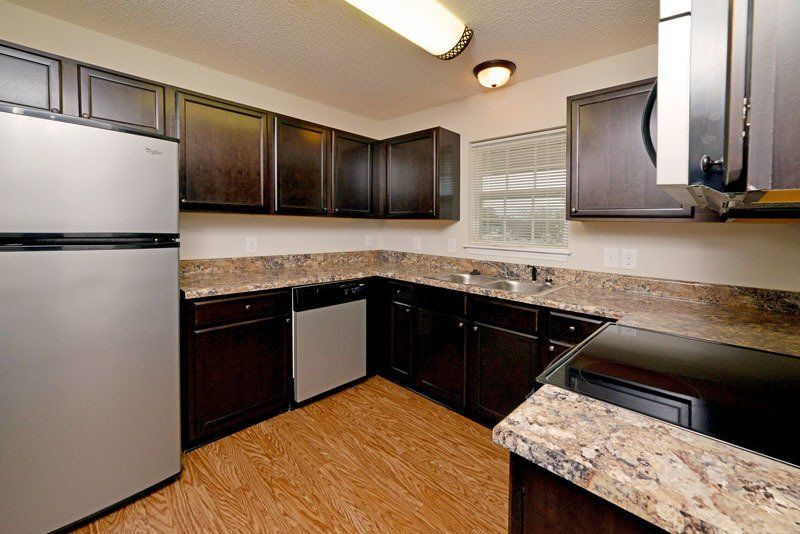 Beacon with dark brown cabinets, stainless steel appliances, and window above sink