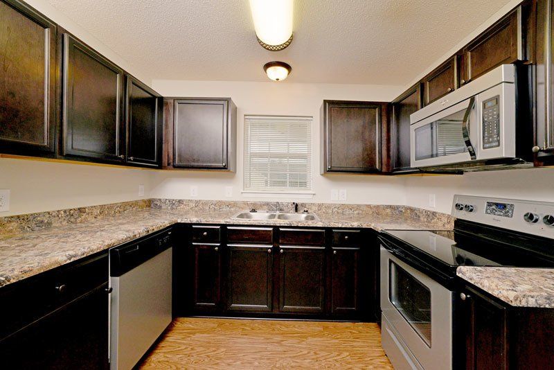 Beacon with dark brown cabinets, stainless steel appliances, and window above sink