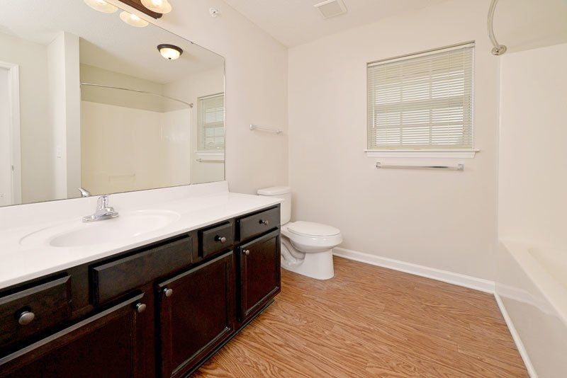 Beacon master bathroom kitchen sink with toilet and window. Partial view of the tub.
