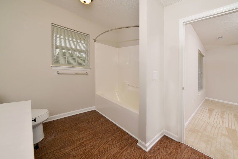 beacon master bathroom view from the vanity- shows the shower with the window on the wall and toilet to the left