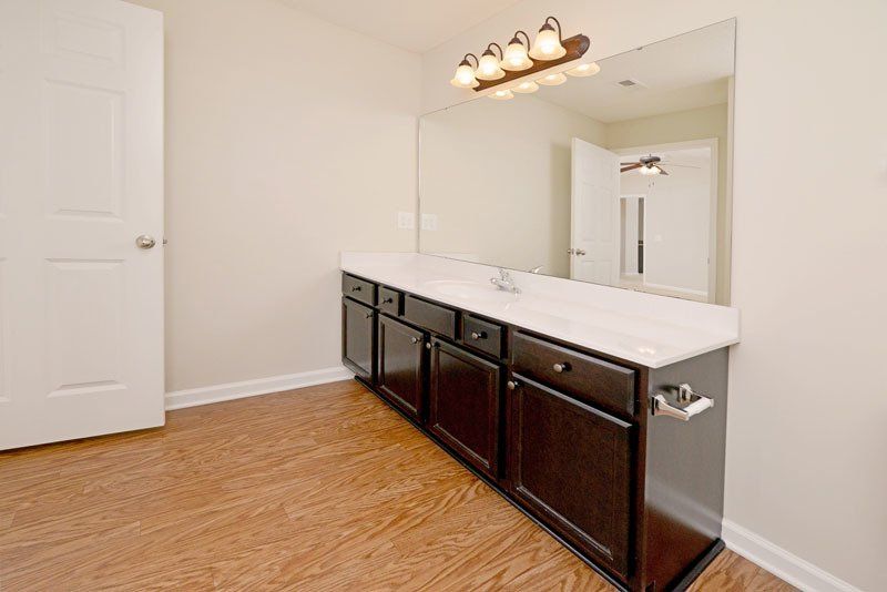 Beacon master bathroom view from the bathtub- shows the vanity/ sink and entrance door