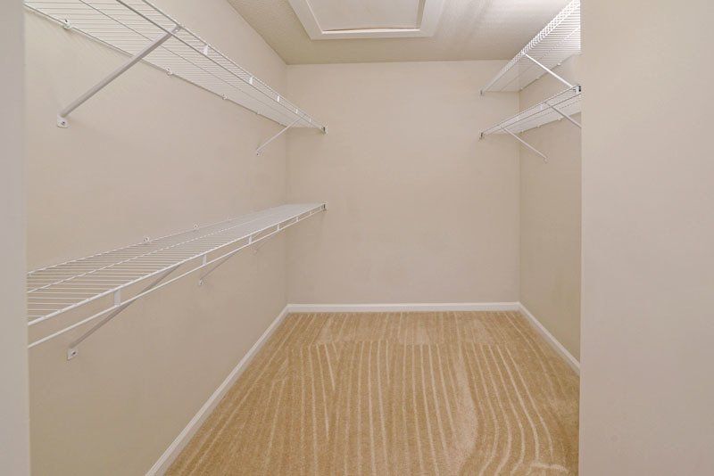Beacon master bedroom walk-in closet. Two racks for clothes to the left above on another and only one rack to the right. 
