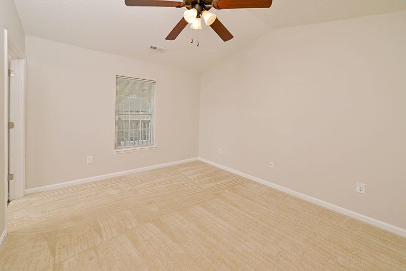 beacons guest room view from where the closet is at- shows the entry way door, cathedral ceilings, ceiling fans, and window