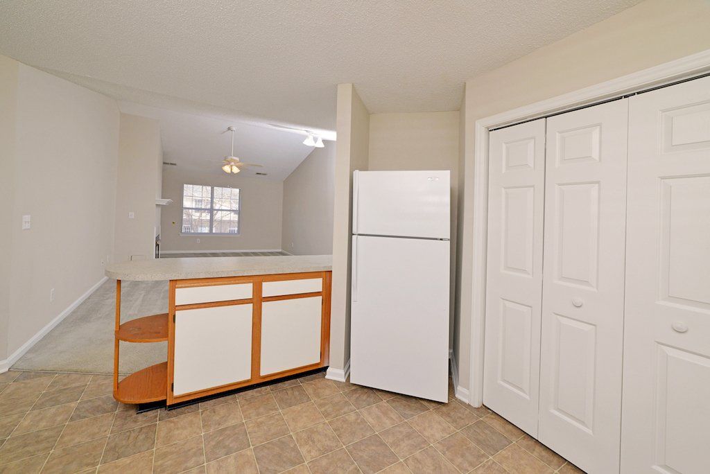 pinnacle kitchen 2-toned cabinets with view of the fridge, cabinets, and dinning room to living room area