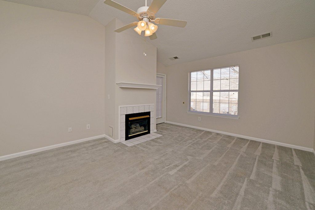 pinnacle view of living room: fireplace, cathedral ceilings, ceiling fan, window