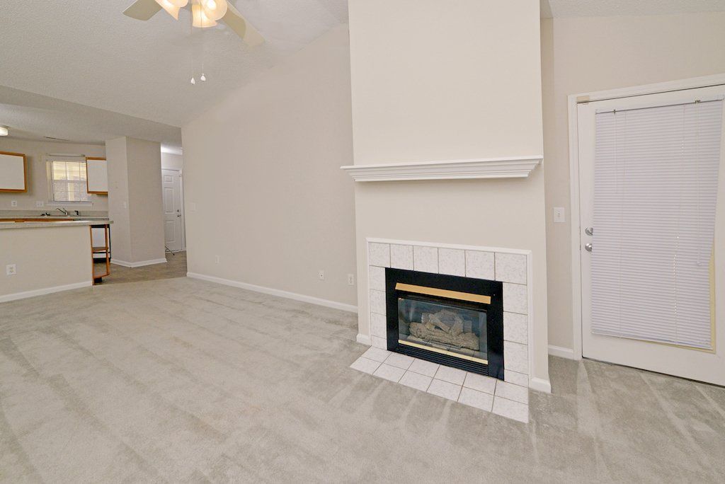 pinnacle view of living room: fireplace, cathedral ceilings, ceiling fan, window
