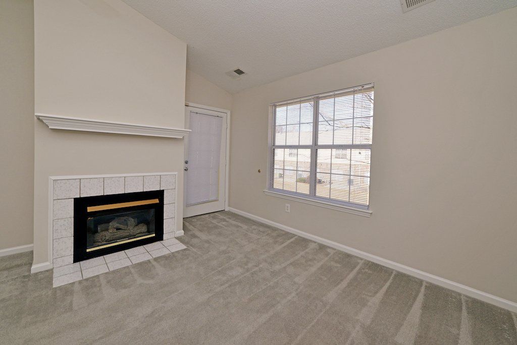 pinnacle view of living room: fireplace, cathedral ceilings, ceiling fan, window