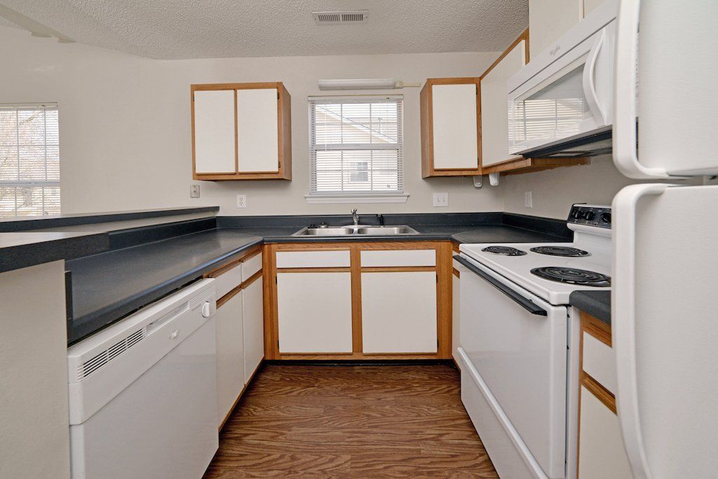 Summits kitchen 2-toned cabinets, sink, window, white dishwasher, white stove, and white fridge