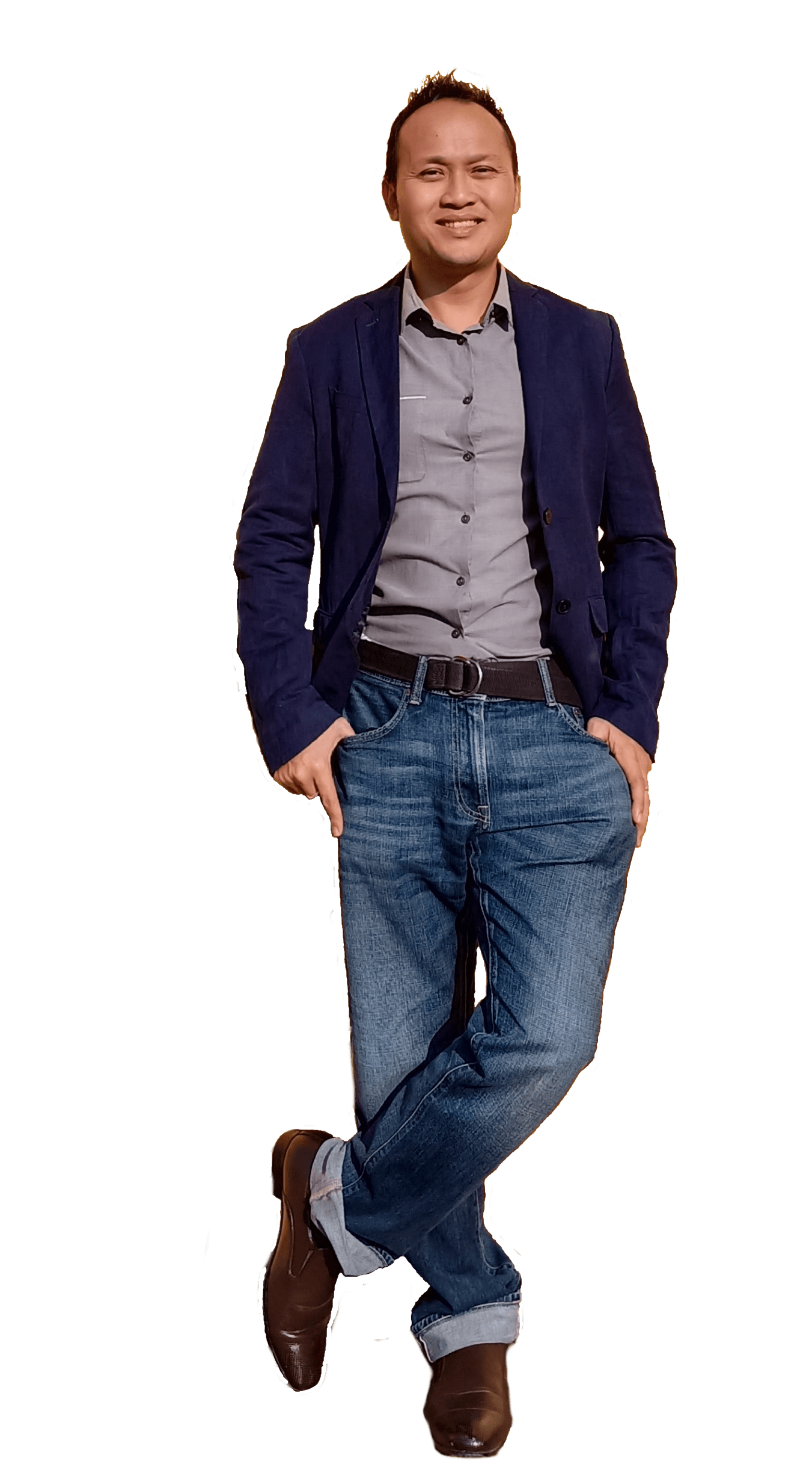 Man in blazer and jeans, leaning with crossed legs, smiling.