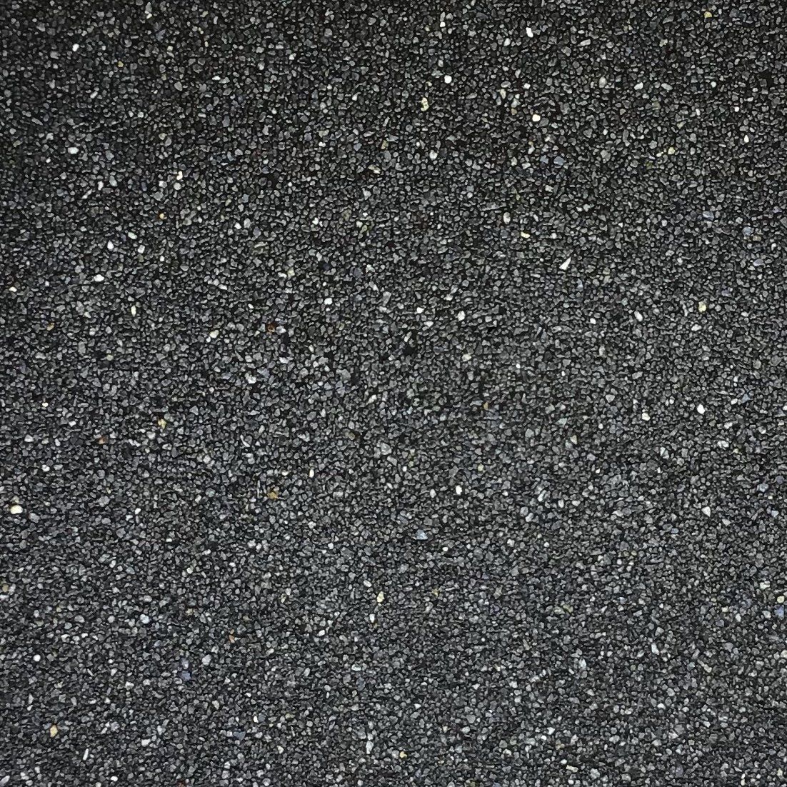Dark gray, textured surface with subtle light flecks and a grid pattern.