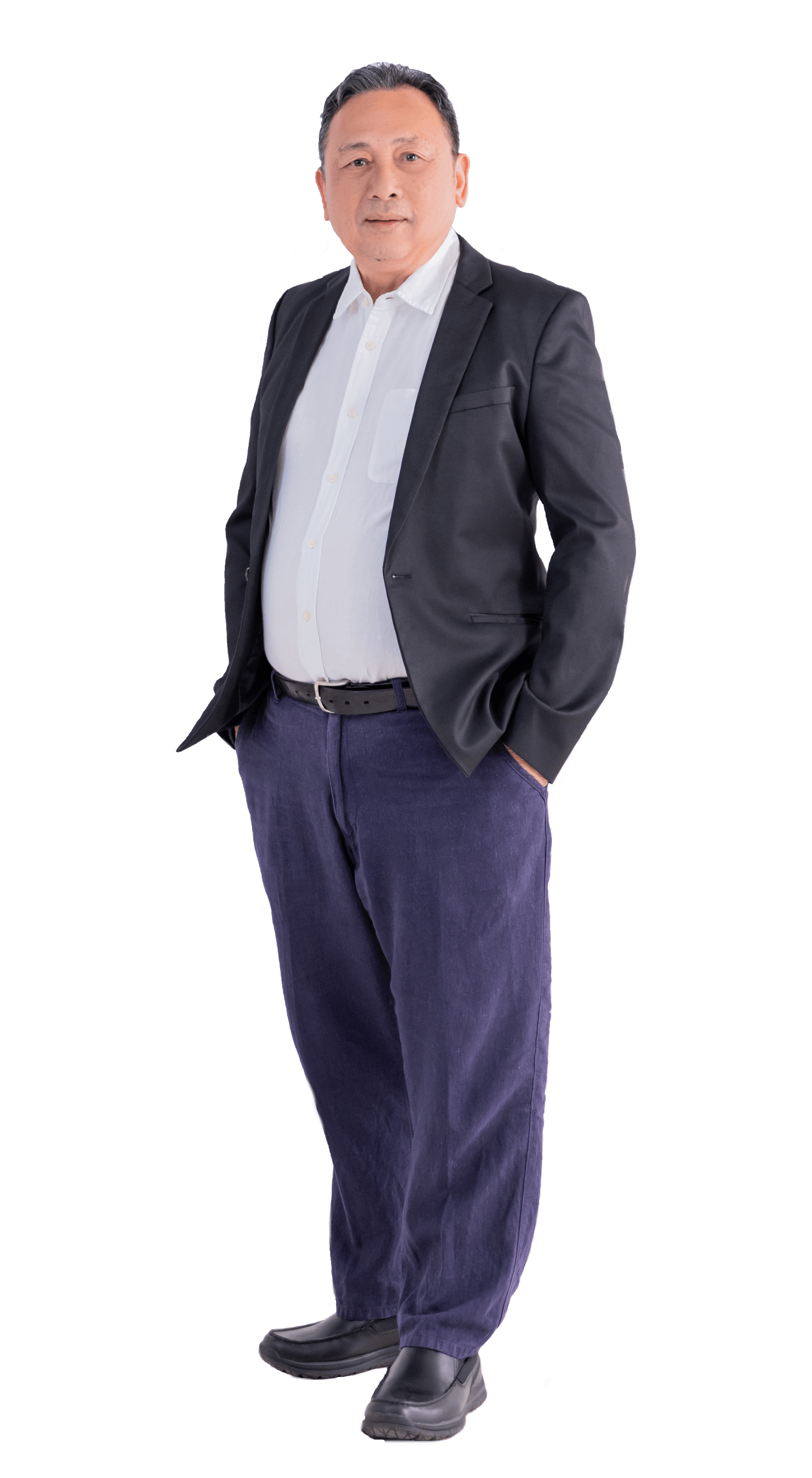 Man in a suit jacket, white shirt, and blue pants, hands in pockets, posing against a white background.