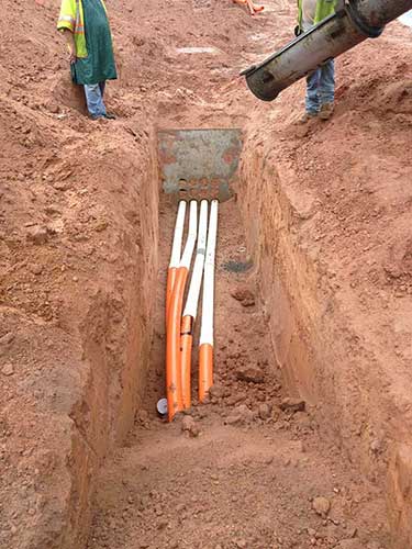 Workers Installing Pipes Underground — Infrastructure Services in Piedmont, SC