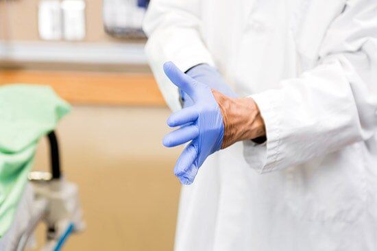 Medical Staff Putting On Gloves — Drug Testing And Training Solutions in Rockhampton, QLD