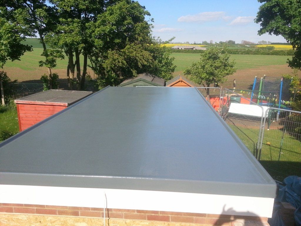 A roof with a view of a field and trees