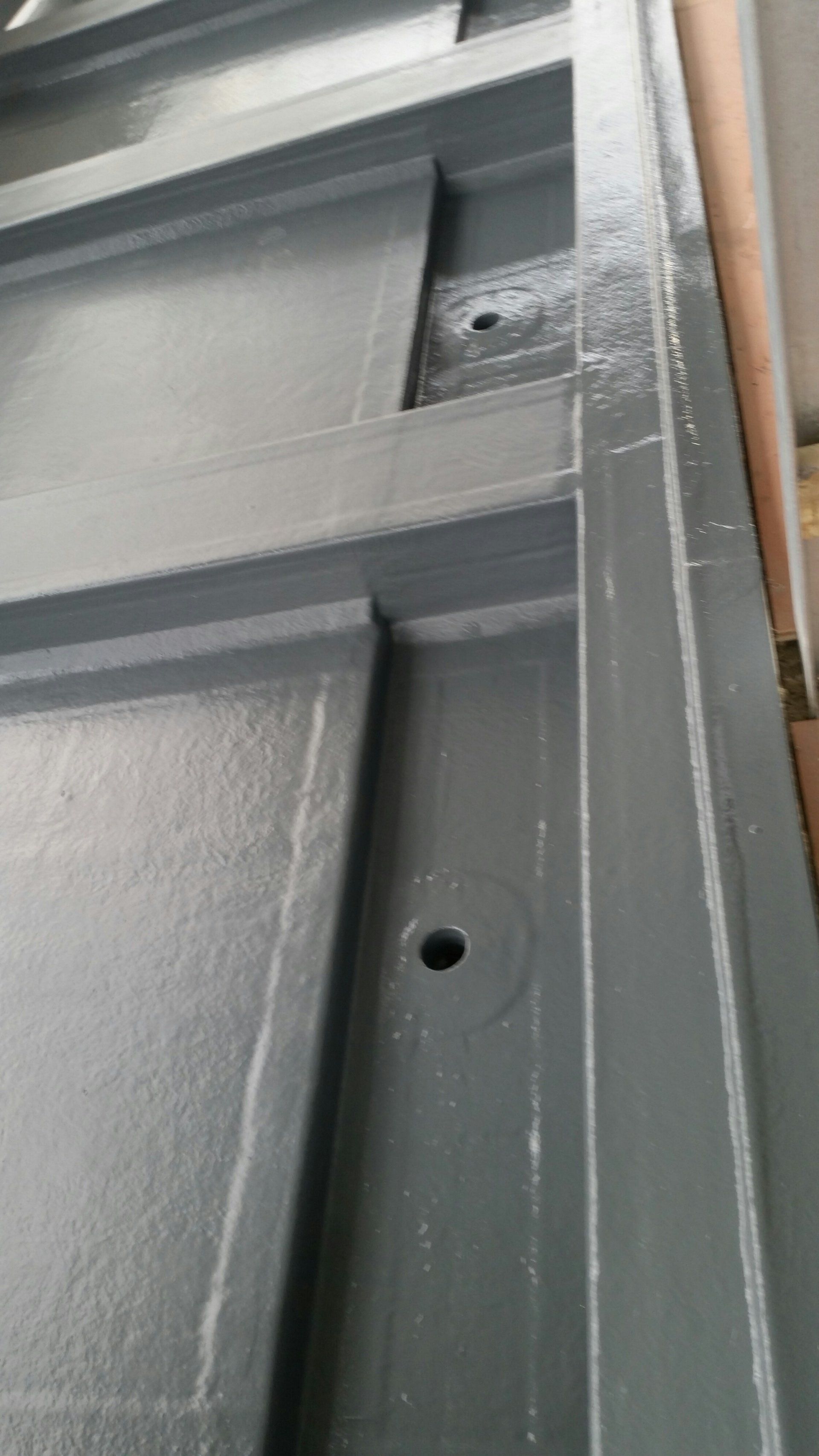 A close up of a metal door with a hole in it.