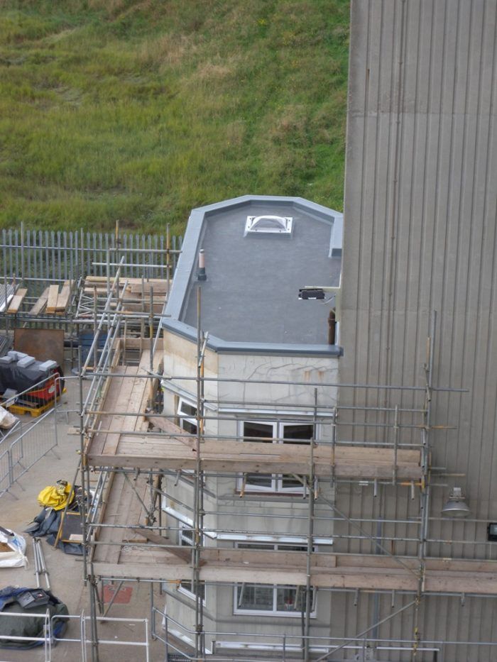 An aerial view of a building under construction with scaffolding around it.