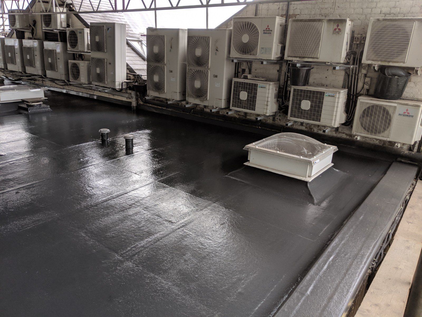 A roof with a lot of air conditioners on it.