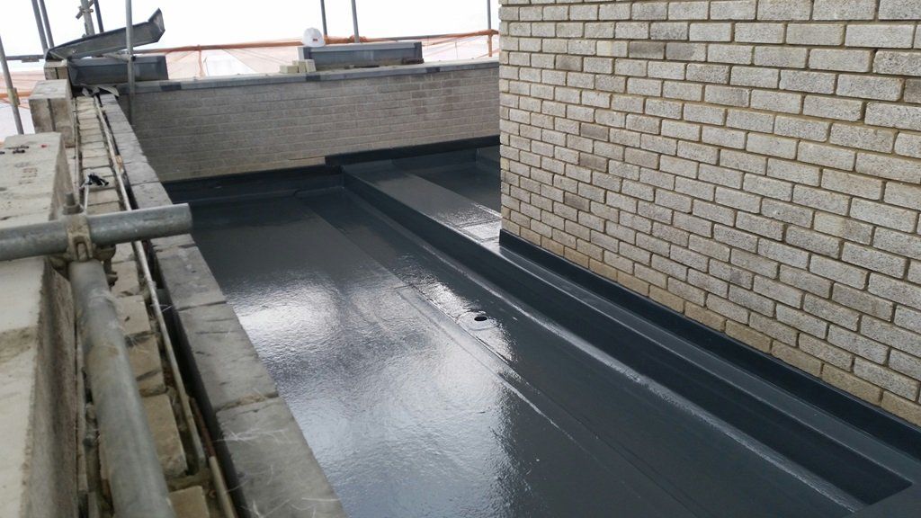 A brick wall with a drain on the side of it.