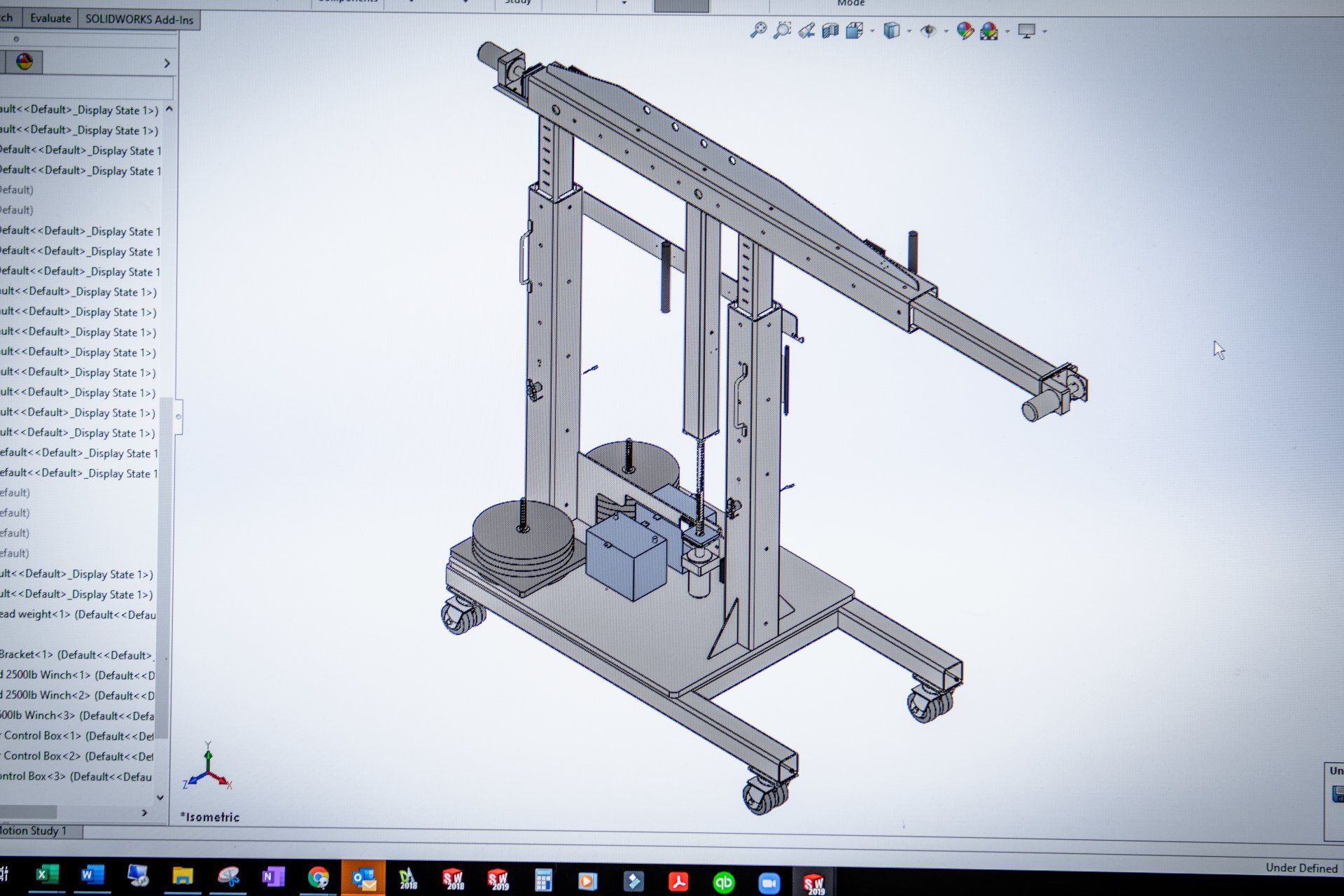 A 3D CAD design on a computer screen showing a mobile crane assembly with a base, vertical supports, and an extended arm.