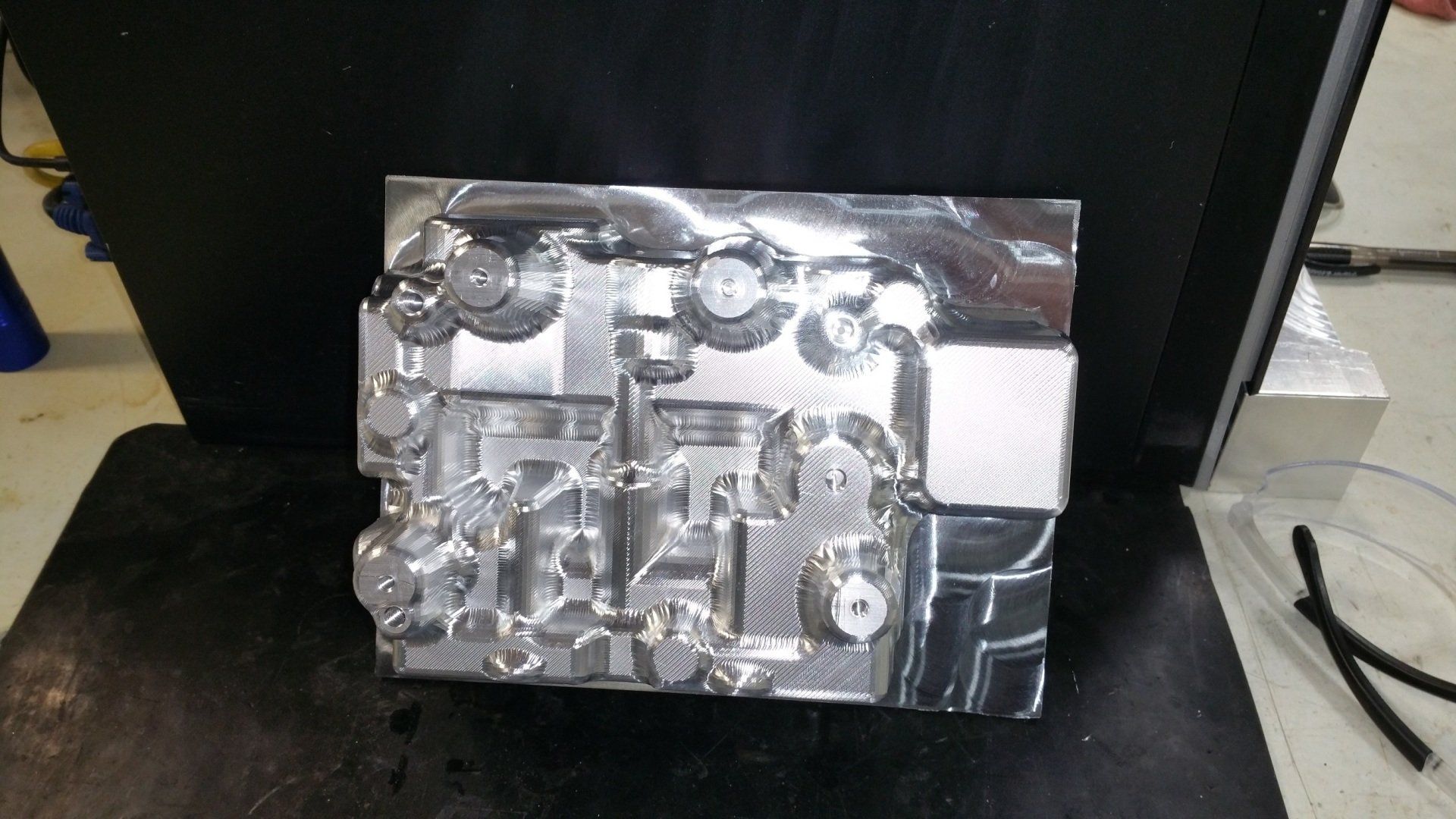 A highly reflective, silver-colored metal mold featuring intricate geometric cavities and precision-machined channels.