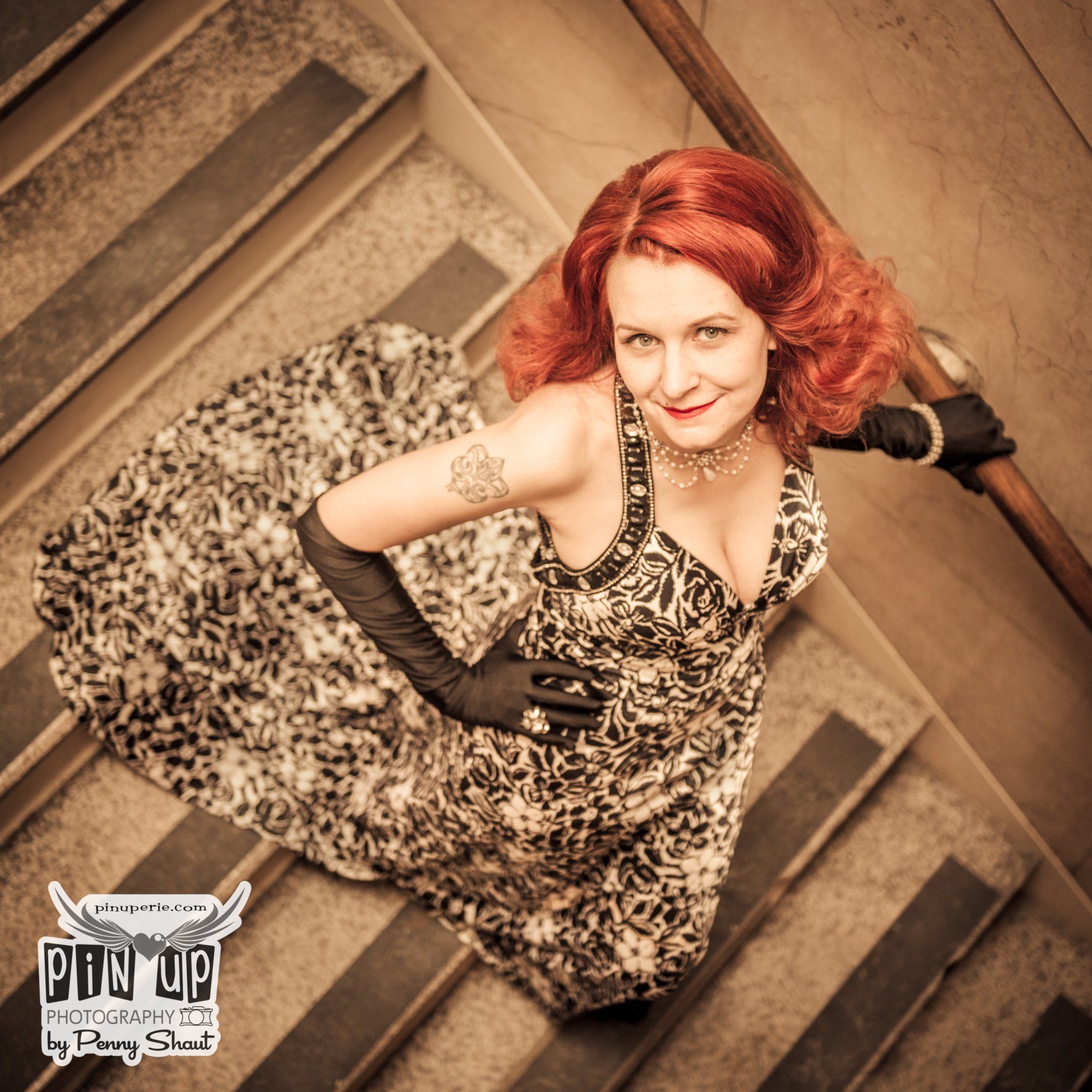 a woman in a leopard print dress is sitting on a set of stairs