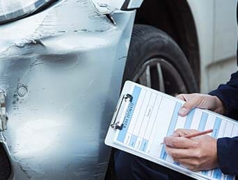 Mechanic Inspecting Damage To Car — Collision Repair in Portland, OR Mechanic Inspecting Damage To Car — Collision Repair in Portland, OR