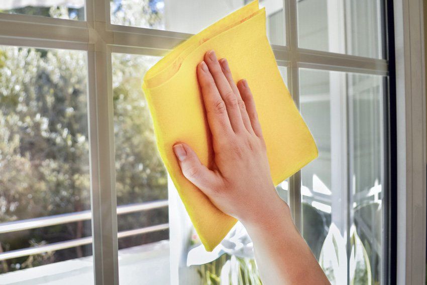 Woman cleaning a window with yellow cloth
