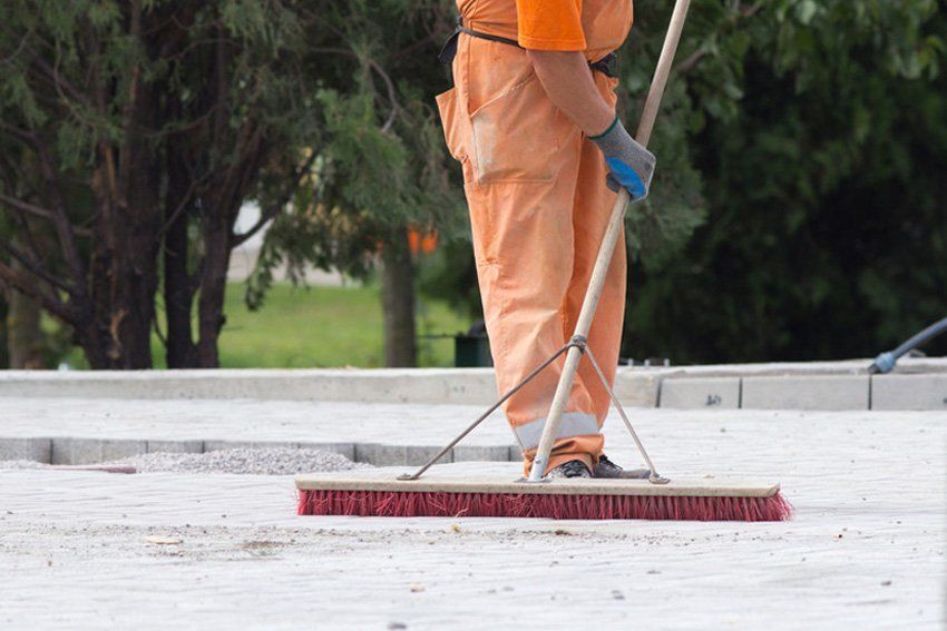 Construction worker sweeping on the building site