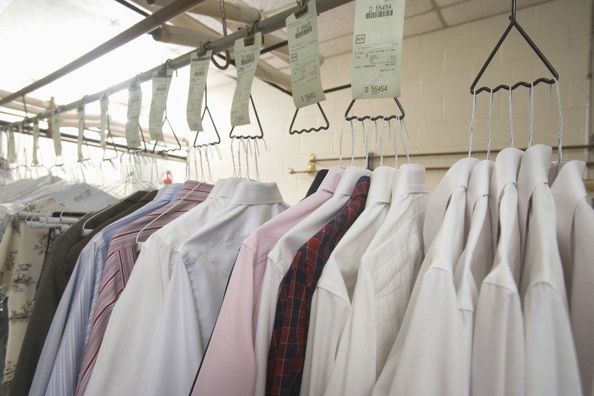 Builders cleaning Row of clean clothes hanging on hanger in laundry
