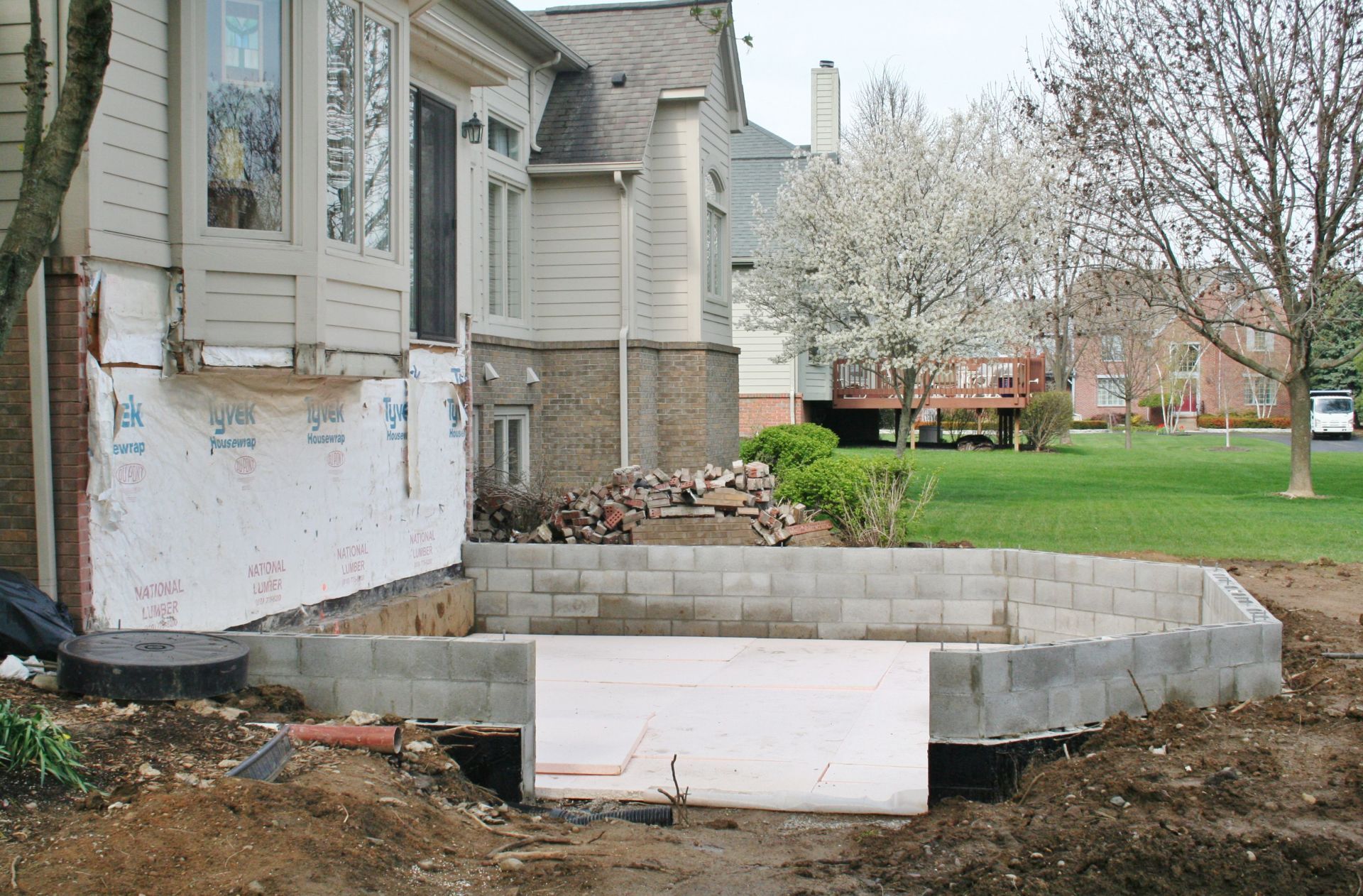 House exterior with newly built gray concrete steps and foundation work in the yard