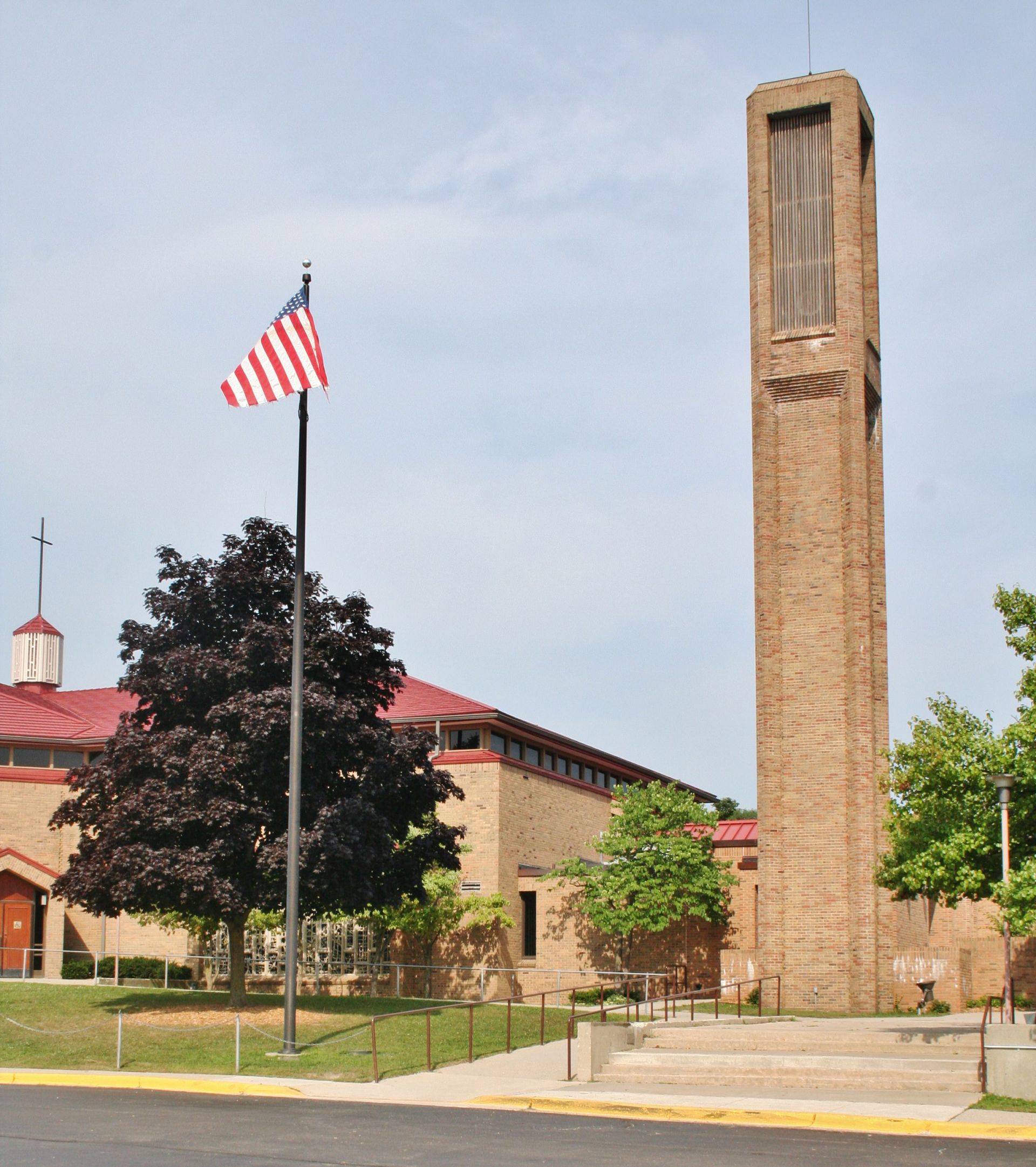 Brick church with tall tower and U.S. flag on a sunny day
