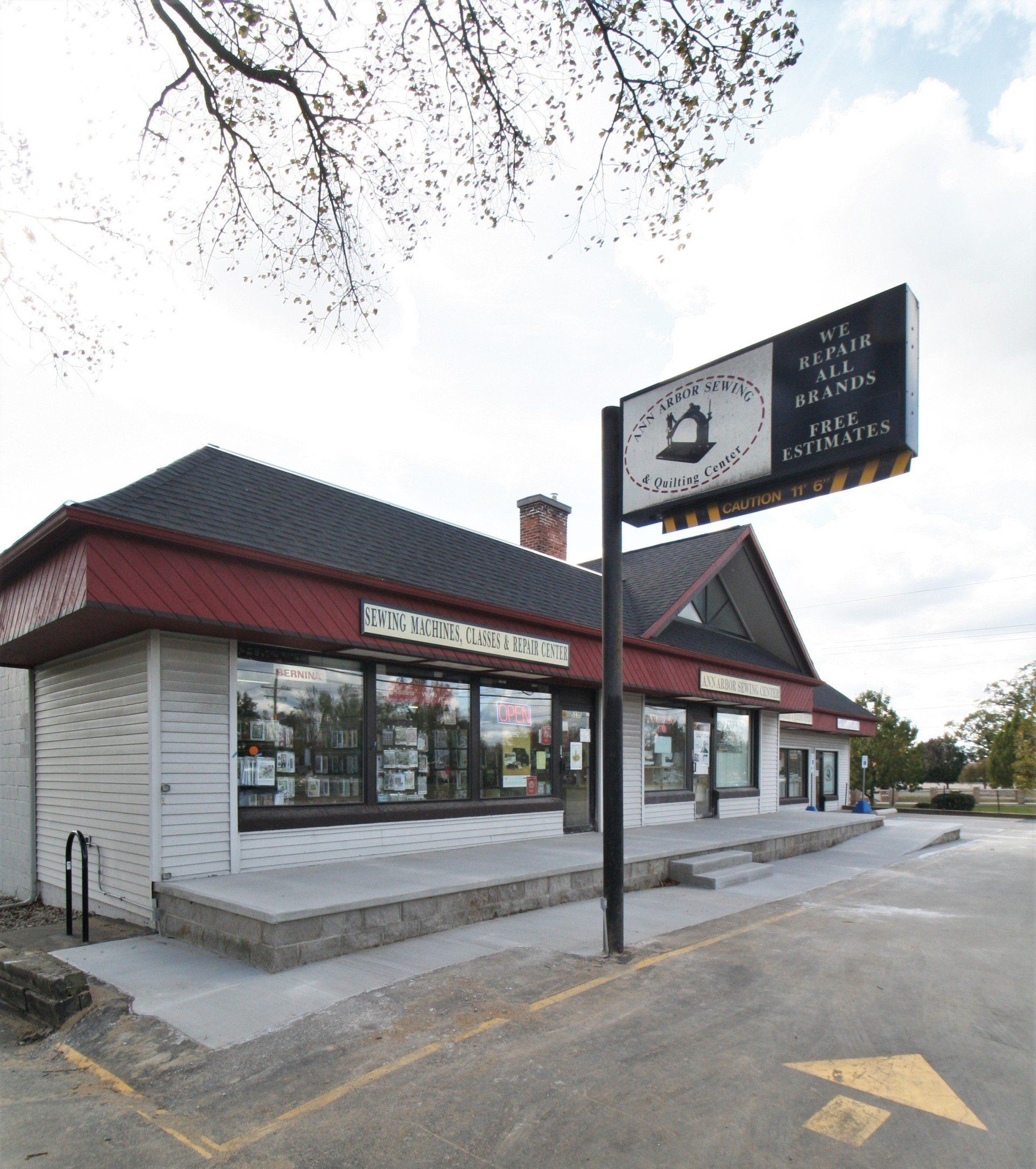 Small roadside restaurant with a black roof and sign, viewed from the parking lot on a cloudy day