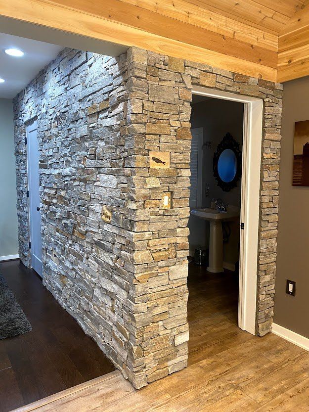Stone accent wall and doorway in a wood-floored home interior