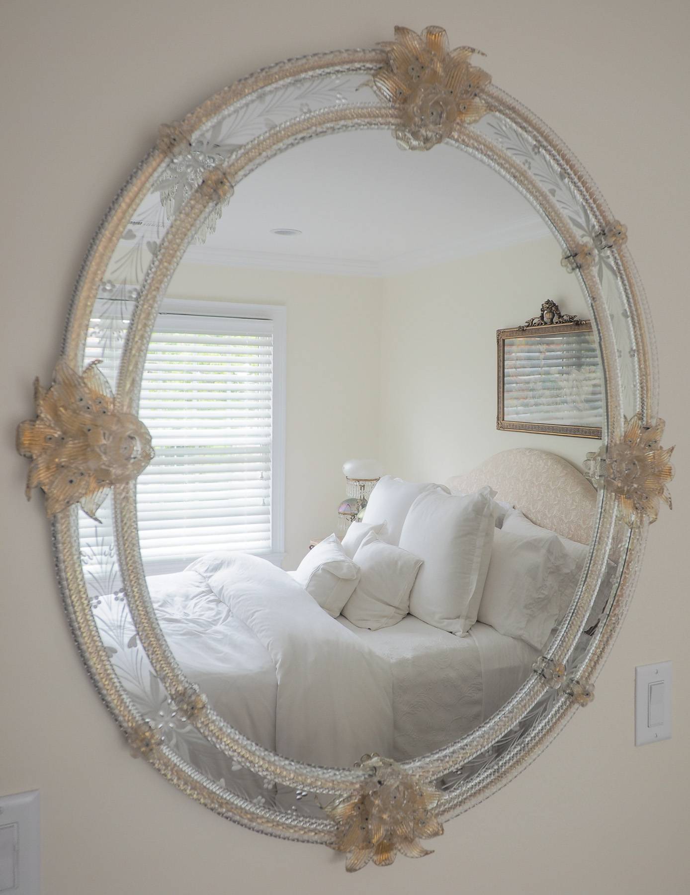 circular mirror with a white bed reflecting