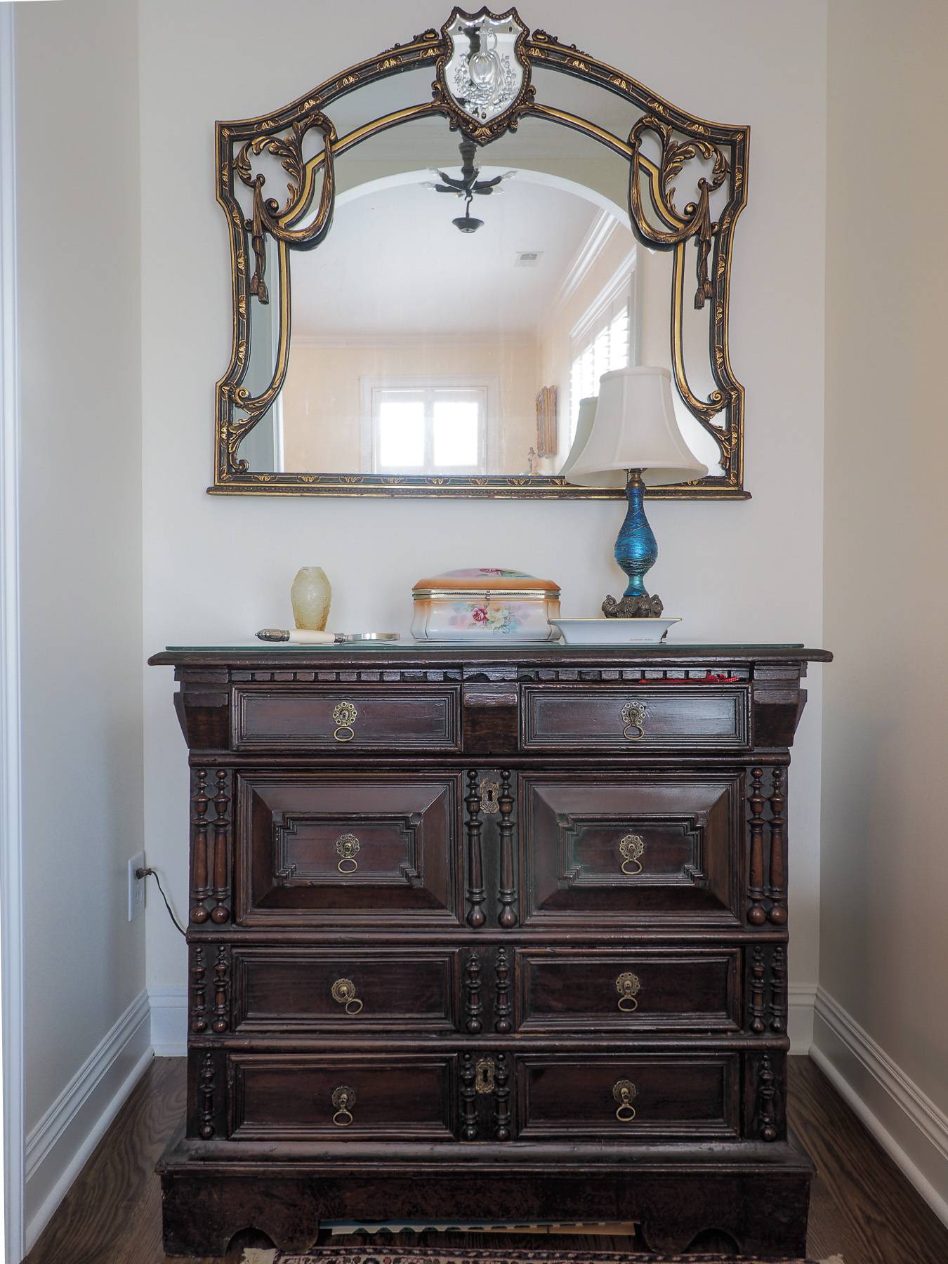 fancy dark brown dresser with a mirror above it