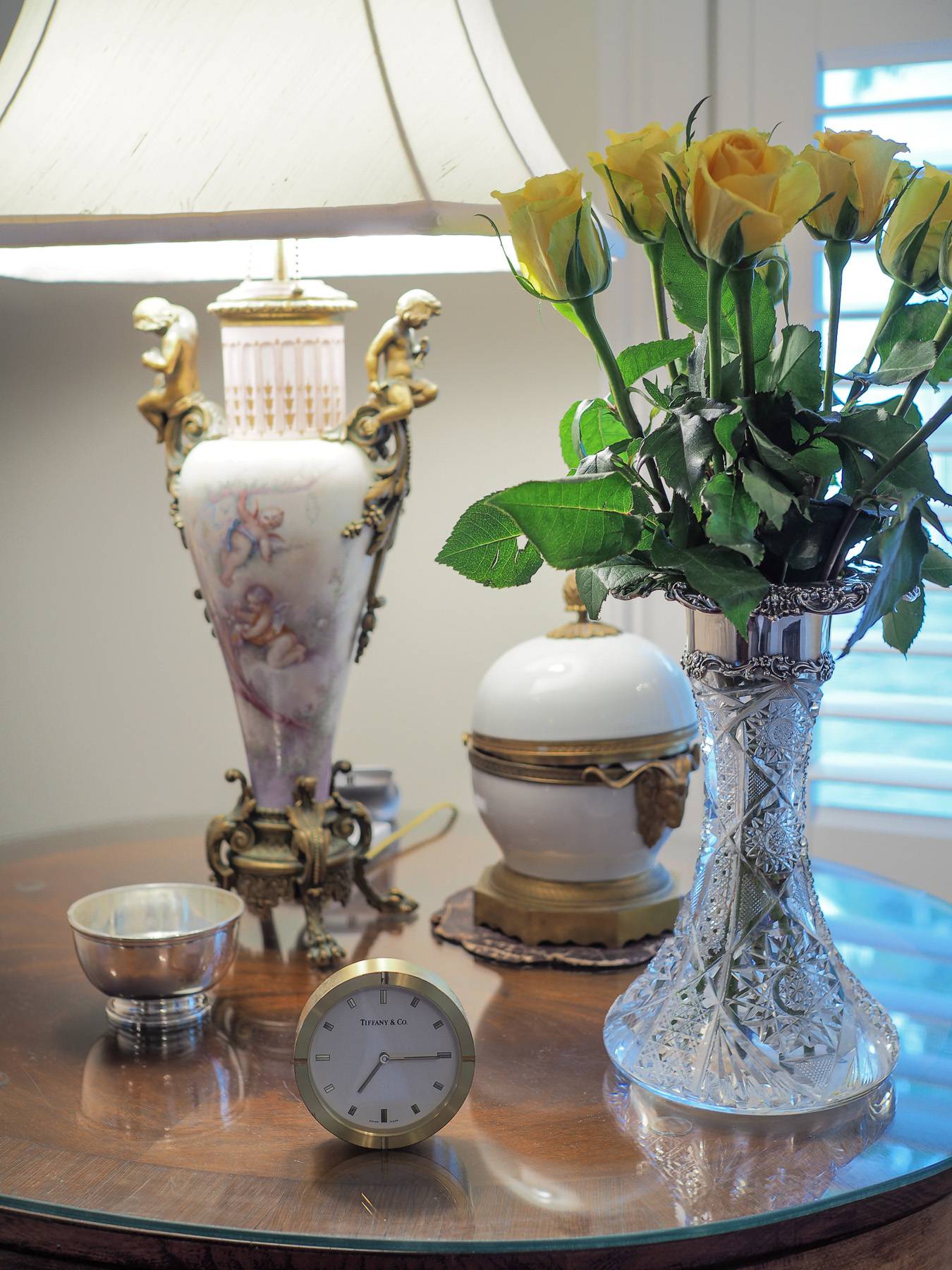 fancy decor on a table like a small clock, a glass vase, and a little chest