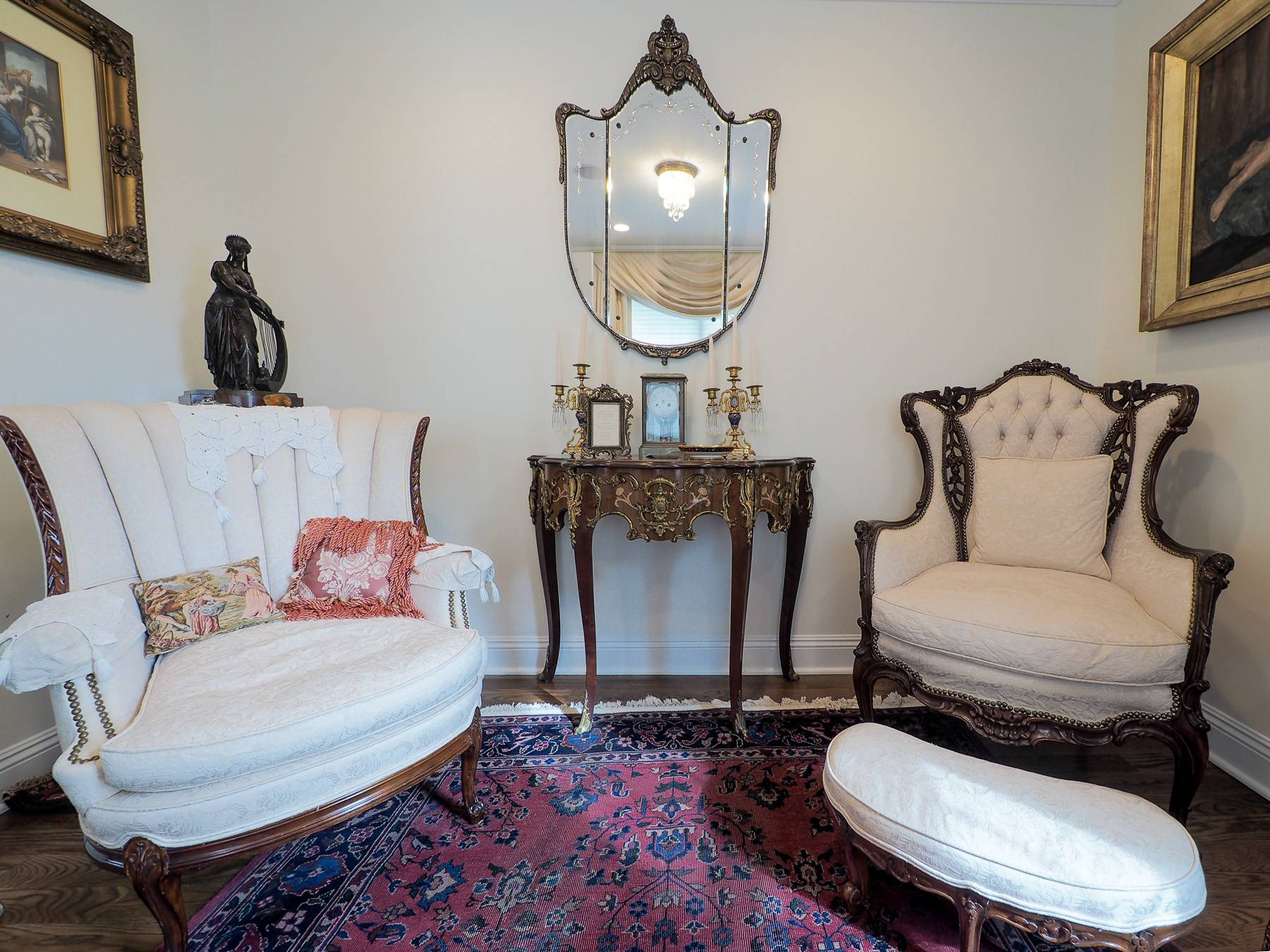 two seats, a decorative table and mirror