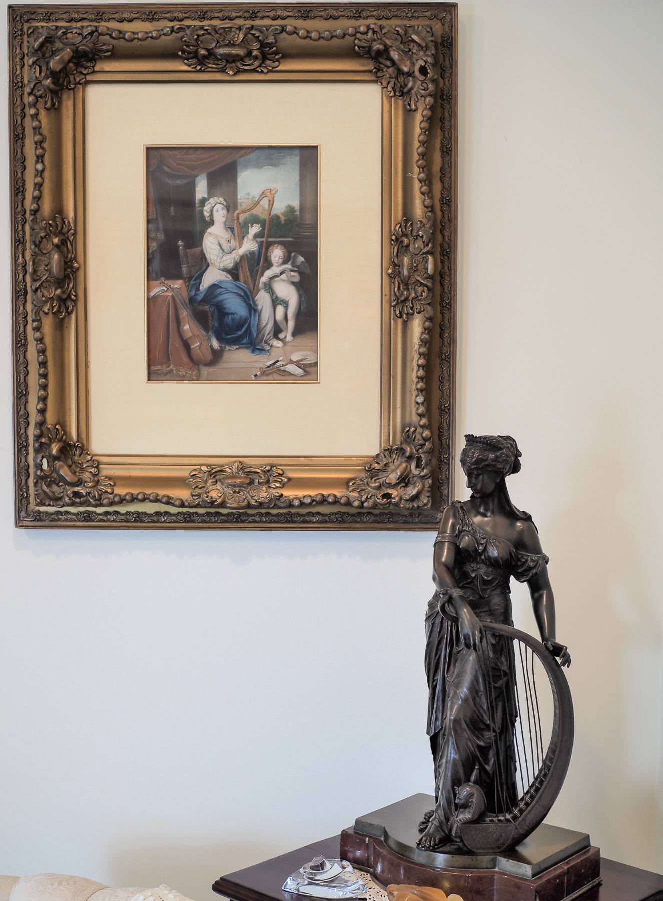 little statue and picture in fancy frame