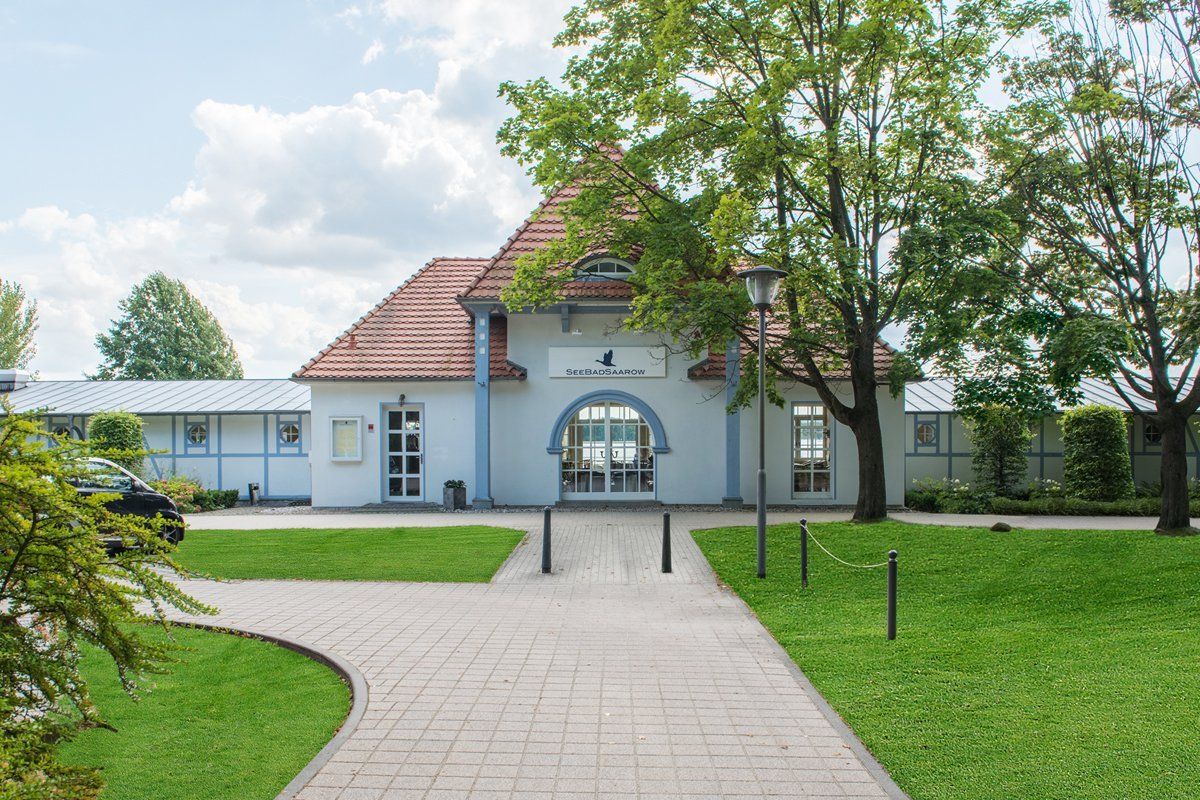Ein weißes Gebäude mit einem roten Dach und einem Gehweg, der dorthin führt
