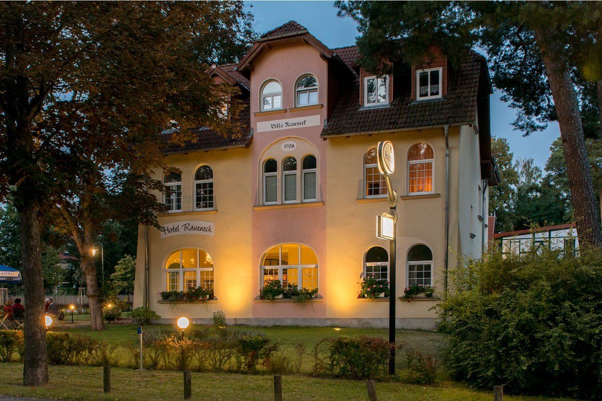 Ein großes Haus mit vielen Fenstern ist nachts beleuchtet