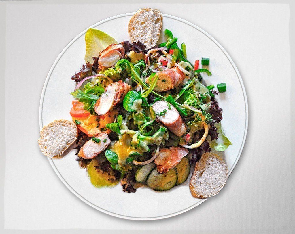 Ein weißer Teller mit Salat und Croutons