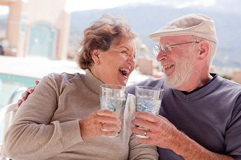 Senior Couple Smiling And Having Drinks — Water Pressure System in Damascus, OR Senior Couple Smiling And Having Drinks — Water Pressure System in Damascus, OR