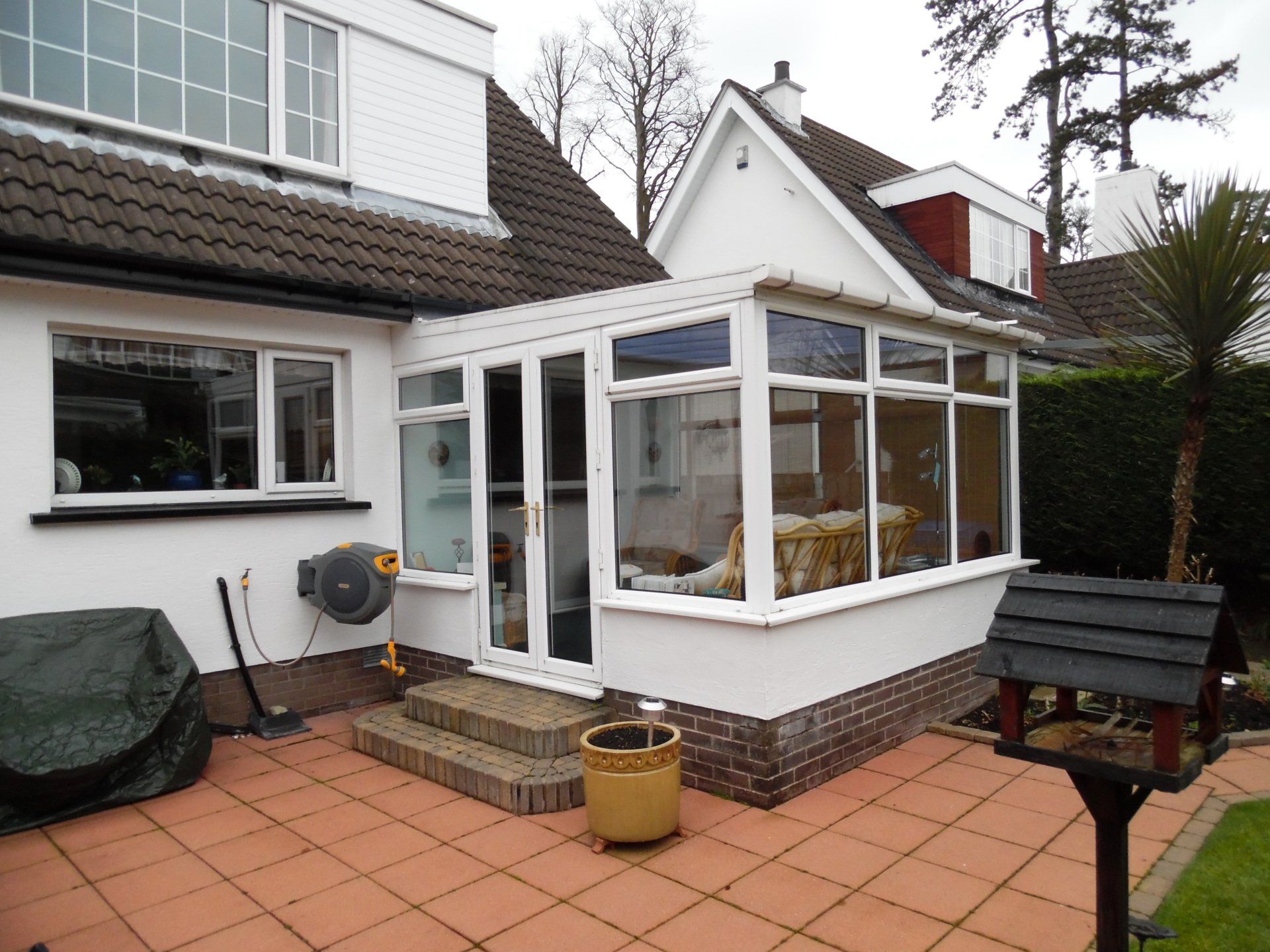 A white house with a conservatory on the side of it