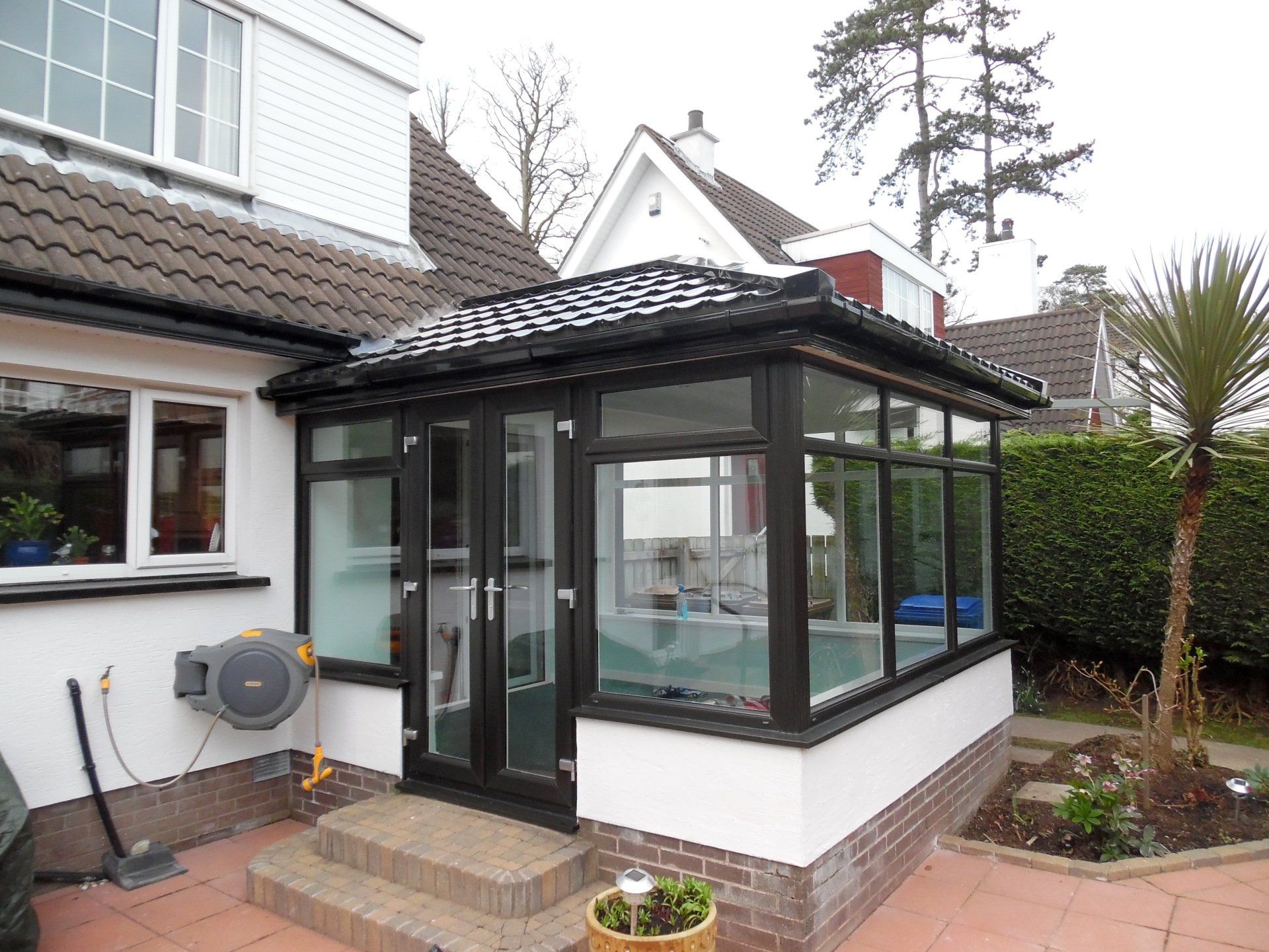 A white house with a black conservatory on the side