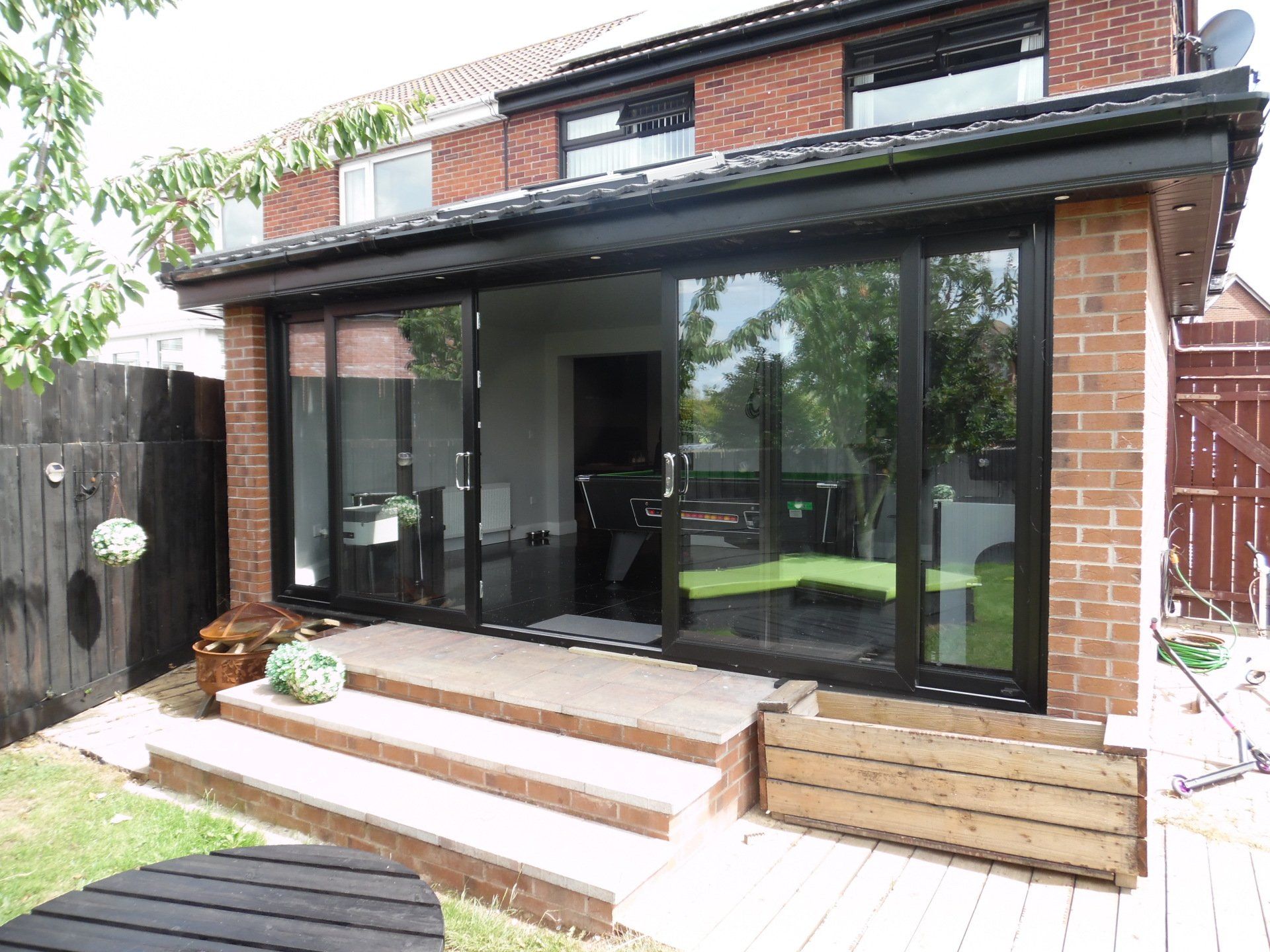 A house with a large sliding glass door and stairs leading to it.