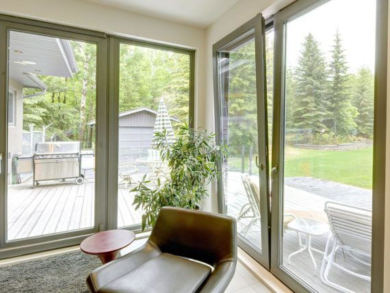A living room with lots of windows and a chair