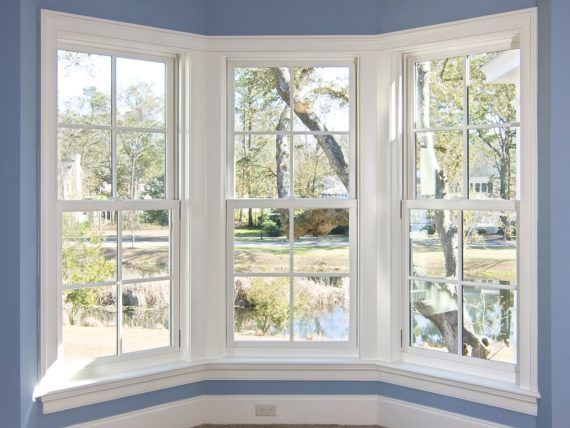 There are three windows in a room with blue walls.