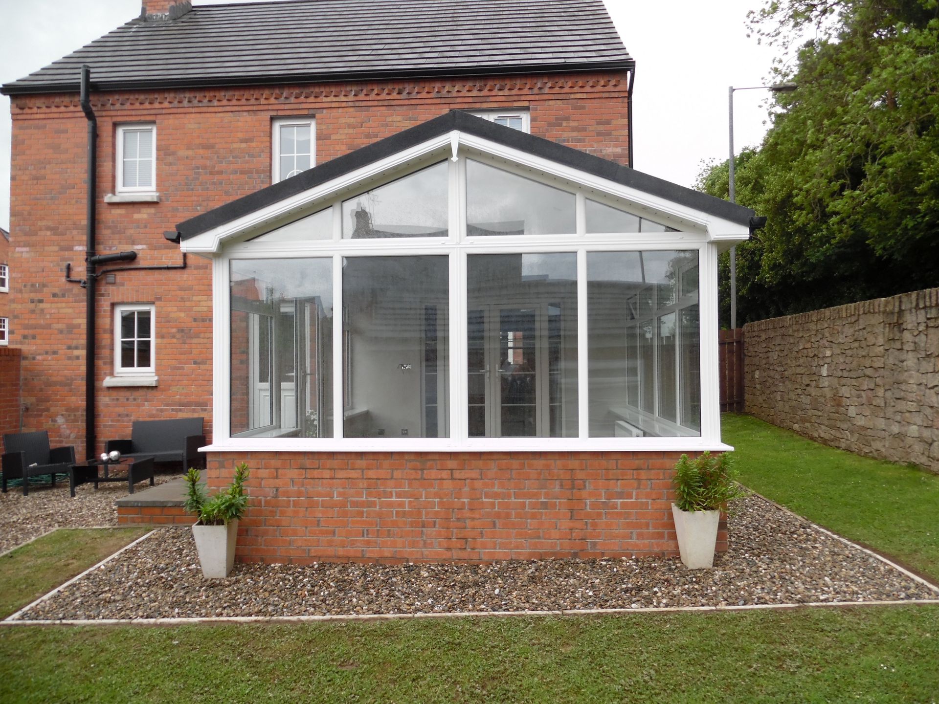 A brick house with a conservatory attached to it